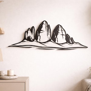 Può includere: Arte da parete in metallo nero raffigurante una silhouette stilizzata di una catena montuosa. L'opera presenta una serie di picchi e valli, creando un design paesaggistico minimalista. Questo pezzo decorativo è adatto per l'arredamento della casa o dell'ufficio.