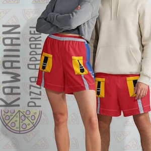 May include: Two people wearing red shorts with yellow pockets and a black guitar design. The shorts have blue and silver accents. The background features a pizza slice pattern and the text "KAWAIIAN PIZZA APPAREL".