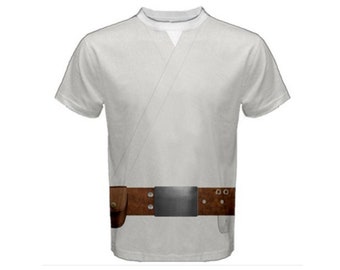 Puede incluir: Una camiseta blanca con un cinturón marrón y una hebilla plateada. La camiseta tiene un diseño que parece una túnica.
