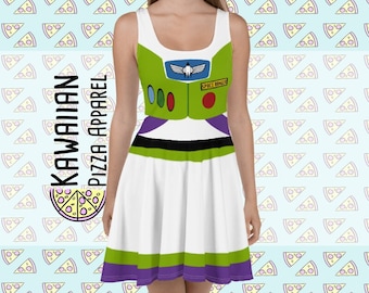 Puede incluir: Un vestido blanco, verde y morado con una imagen impresa de Buzz Lightyear de la franquicia de películas Toy Story. El vestido tiene un escote redondo y un corpiño ajustado. La falda es una falda de círculo completo. El vestido tiene una imagen impresa del traje de ranger espacial de Buzz Lightyear, incluyendo su casco, pieza de pecho y cinturón. El vestido también tiene el texto "SPACE RANGER" impreso en la pieza de pecho.