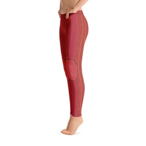 May include: Red leggings with a geometric pattern featuring orange and black accents. The leggings have a unique design that resembles a honeycomb pattern.