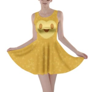 May include: A yellow sleeveless dress with a heart-shaped smiley face design. The dress has a flared skirt and a sparkly pattern.