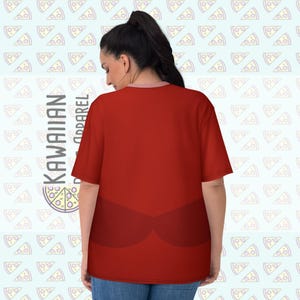 Puede incluir: Camiseta roja con un dise&ntilde;o rojo oscuro en la parte delantera. La camiseta tiene mangas cortas y cuello redondo. Las palabras "KAWAIIAN APPAREL" est&aacute;n impresas verticalmente en el lado izquierdo de la camiseta. El fondo es azul claro con patrones de rebanadas de pizza.