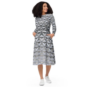 Puede incluir: Un vestido midi de estampado geométrico gris y blanco con mangas largas y bolsillos. El vestido tiene un corpiño ajustado y una falda acampanada.