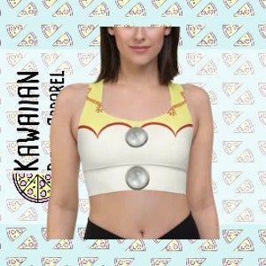 Puede incluir: Un sujetador deportivo blanco con un diseño amarillo y rojo. El sujetador tiene un escote redondo y un estilo de espalda de nadador. El diseño presenta un personaje de dibujos animados con una nariz de botón y dos botones.