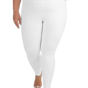 a woman wearing white pants and a bra