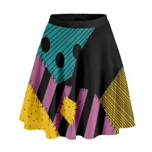 Puede incluir: Una falda negra, rosa, amarilla y azul de patchwork con un diseño caprichoso. La falda tiene una silueta acampanada y está hecha de una tela suave y cómoda.