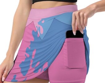 May include: Pink and blue athletic skirt with a wraparound design and built-in shorts. The skirt features a pocket on the side and a colorful abstract pattern. The waistband is pink, and the shorts are a solid pink color.