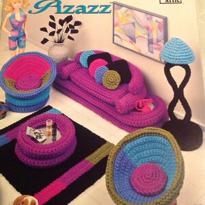 Puede incluir: Un conjunto de muebles de casa de muñecas de ganchillo con un sofá, dos sillas, una mesa de café y una lámpara de pie. Los muebles están hechos en una variedad de colores, incluyendo rosa, azul, verde y marrón. El conjunto está diseñado para ser utilizado con muñecas de moda.