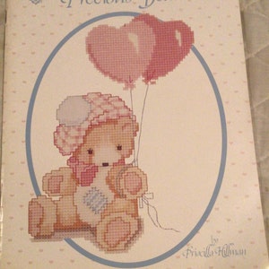 Peut inclure: Modèle de point de croix d'un adorable ours en peluche tenant des ballons en forme de cœur. Le modèle est intitulé "Priscilla's Precious Bears" et est de Priscilla Hillman.
