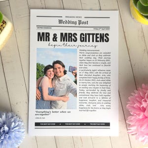 May include: A white rectangular wedding announcement printed to resemble a newspaper titled Wedding Post. It features a photograph of a couple, the headline MR & MRS GITTENS begin their journey, and text detailing their relationship history.