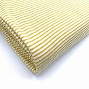 May include: A close-up of a yellow and white striped fabric. The fabric is folded and has a soft, textured feel.