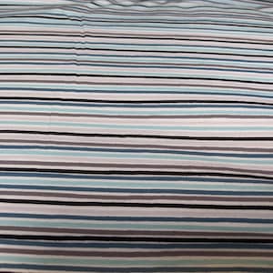 May include: White fabric with horizontal stripes in shades of blue, gray, and black.