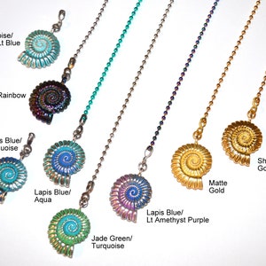 May include: A collection of decorative ceiling fan pull chains. The chains feature spiral-shaped pendants in various colors, including turquoise, dark rainbow, lapis blue, jade green, and shiny gold. Text on the image indicates the color variations.