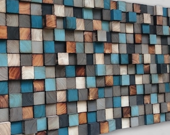 May include: A wall art piece made of wood blocks in various shades of blue, brown, and gray. The blocks are arranged in a staggered pattern, creating a textured and modern look.