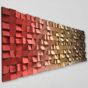 Può includere: Una scultura da parete in legno con un gradiente di colori rosso, arancione e marrone. La scultura è composta da molti piccoli quadrati disposti a formare un motivo.