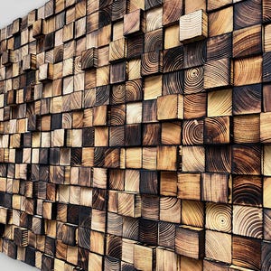May include: A wall art installation composed of numerous wooden blocks. The blocks vary in color from light tan to dark brown, with visible wood grain patterns. The arrangement creates a textured, three-dimensional effect, suitable for interior decor.