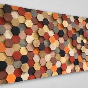 May include: A wall art piece made of wooden hexagons in various shades of brown, red, orange, and black. The hexagons are arranged in a staggered pattern, creating a three-dimensional effect.