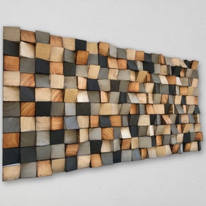 Könnte beinhalten: Ein Wandkunstwerk aus Holzblöcken in verschiedenen Brauntönen, Grautönen und Schwarz. Die Blöcke sind in einem versetzten Muster angeordnet, wodurch ein strukturierter und dreidimensionaler Effekt entsteht.