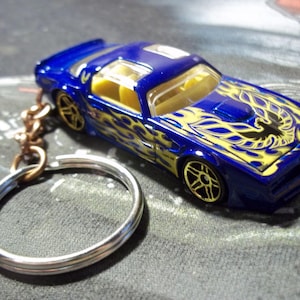 custom made stock keychain 1977 pontiac firebird coupe,gloss blue w/yellow flames-bird,gold mags-hand made chain and jumpring-mint