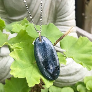 Peut inclure: Un collier en cha&icirc;ne argent avec un pendentif ovale bleu et blanc. Le pendentif est fait d'une pierre naturelle et a un b&eacute;li&egrave;re dor&eacute;e.