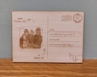 May include: Wooden postcard with a family photo and handwritten text. The postcard is addressed "To Nan" and includes the message "Just a little note to say we think of you every day!" and "Lots of love Amy Hugh & Poppy xx."