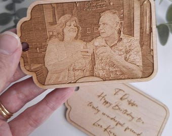 May include: Wooden tag with a laser-etched photograph of a couple, held by a hand. The tag has a decorative shape with a hole. A second tag with handwritten text is also visible. The text reads: "T Debbie Happy Birthday to a truly wonderful friend Love Karen xx".