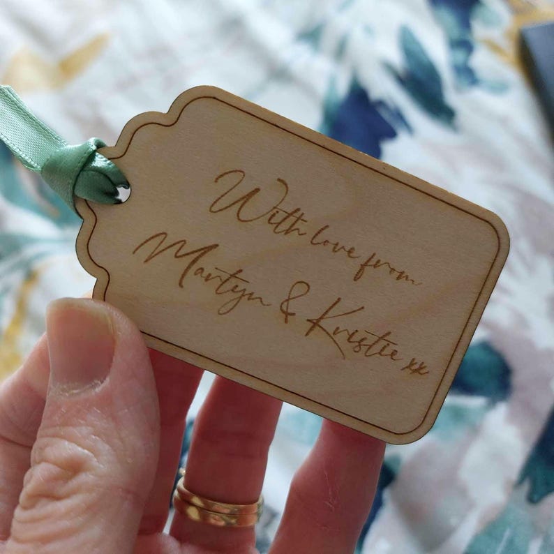 A wooden gift tag with a scalloped edge. It can be personalised with any text