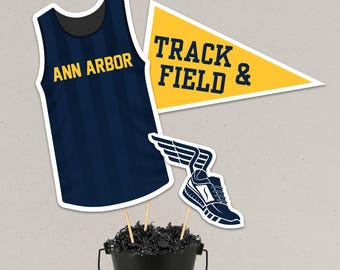 Arranjos de mesa com tema de pista de atletismo em azul marinho e amarelo dourado, decoração para banquete de cross country (arquivo digital)
