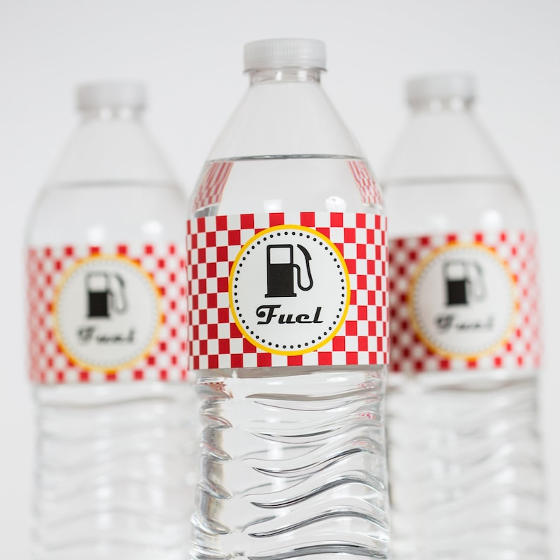 May include: Three clear plastic water bottles with red and white checkered labels. The labels have a yellow circle with a black gas pump icon and the word "Fuel" in black text.