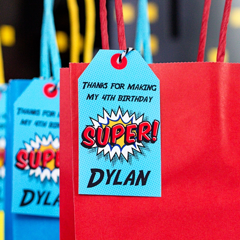 May include: Blue and red superhero-themed party favor bag with a tag that says "Thanks for making my 4th birthday super! Dylan".