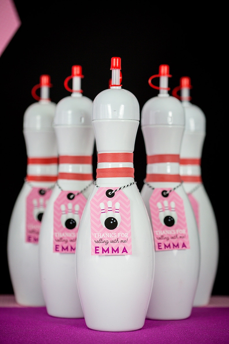 May include: Five white bowling pin shaped bottles with red lids and pink and white chevron patterned tags that say "Thanks for rolling with me! Emma".