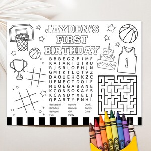 May include: A black and white printable coloring page for a child's first birthday party. The page features a basketball theme with a basketball hoop, basketballs, a basketball jersey, a cake, a trophy, a word search, and a maze. The text on the page reads "Jayden's First Birthday".