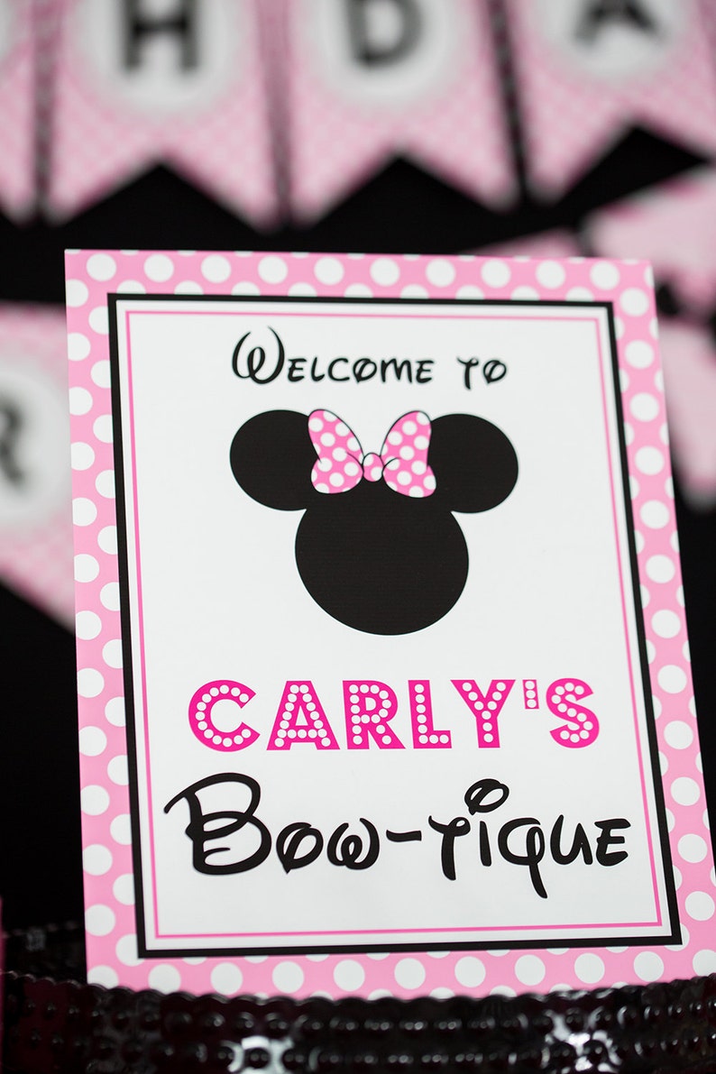 May include: Pink and white polka dot sign with black text that says "Welcome to Carly's Bow-tique" with a black and white silhouette of Minnie Mouse with a pink polka dot bow.