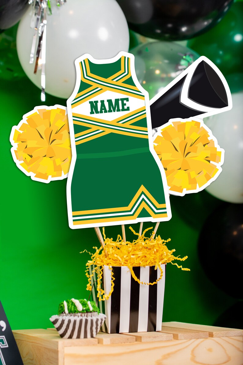 May include: Green and gold cheerleader outfit cutout with the word "NAME" on the front, two yellow pom-poms, a black megaphone, and a black and white striped box filled with yellow shredded paper.