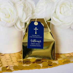 K&ouml;nnte beinhalten: Goldene Geschenkbox mit einem blauen Etikett, auf dem "Vielen Dank f&uuml;r die Feier der Ersten Heiligen Kommunion von Anthony" steht, mit einem goldenen Kreuz auf dem Etikett.