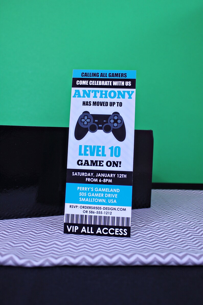 May include: A blue and black invitation with a video game controller graphic. The invitation reads "Calling all gamers, come celebrate with us Anthony has moved up to Level 10 Game On!"  The invitation is for a party on Saturday, 12th January from 6-8pm at Perry's Gameland, 505 Gamer Drive, Smalltown, USA. RSVP: orders@505-design.com or 586-555-1212. VIP All Access.