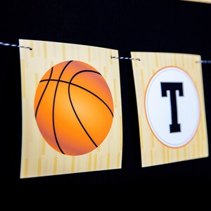 May include: A basketball-themed banner with the word "Party" spelled out in white letters on a yellow and orange background. The banner features a basketball graphic and a wood grain texture.