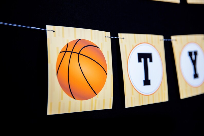 May include: A basketball-themed banner with the word "Party" spelled out in white letters on a yellow and orange background. The banner features a basketball graphic and a wood grain texture.