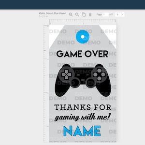 May include: A printable tag with a gray background and a blue circle at the top. The tag features a black and white illustration of a video game controller and the text "GAME OVER", "THANKS FOR gaming with me!" and "NAME".