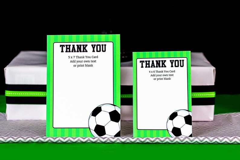 May include: Two green and white soccer-themed thank you cards with a soccer ball graphic. The larger card is 5 x 7 inches and the smaller card is 4 x 6 inches. Both cards have the text "Thank You" and instructions to add your own text or print blank.