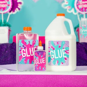 May include: Three bottles of glue with colorful labels. The labels feature a pink, blue, and purple splatter design with the word "GLUE" in white letters. The bottles are on a pink surface.