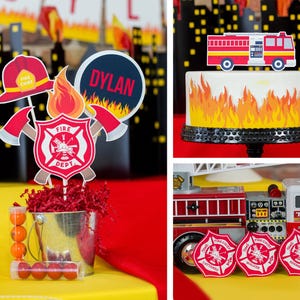May include: Firefighter themed party decorations with a red fire truck, a cake with flames, and a centerpiece with a fire department logo, a fire chief hat, and the name "DYLAN".