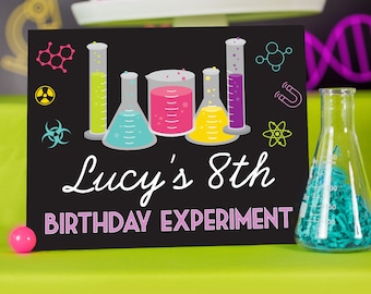 May include: Black chalkboard sign with colourful beakers and science symbols. The sign reads "Lucy's 8th Birthday Experiment".