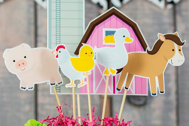 Puede incluir: Un conjunto de adornos para cupcakes con tem&aacute;tica de animales de granja. Los adornos incluyen un cerdo rosa, una gallina blanca, un pollito amarillo, un pato blanco, un caballo marr&oacute;n y un granero rosa.