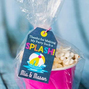May include: A pink and white popcorn container with a thank you tag that says "Thanks for Making My Party Such a SPLASH! Mia & Mason". The tag has a blue and yellow beach ball graphic.