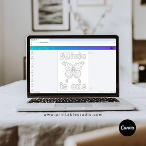 May include: A laptop screen displaying a digital design file with a white background. The design features a black outline of a butterfly centred between the text Alivia at the top and the text is one at the bottom in a rounded font.