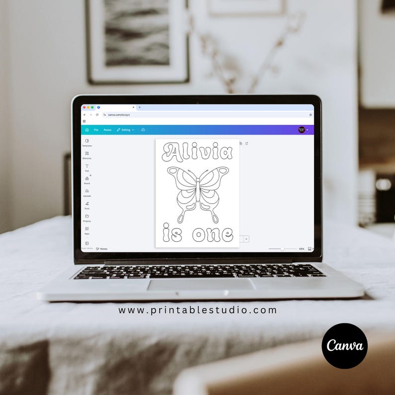 May include: A laptop screen displaying a digital design file with a white background. The design features a black outline of a butterfly centred between the text Alivia at the top and the text is one at the bottom in a rounded font.