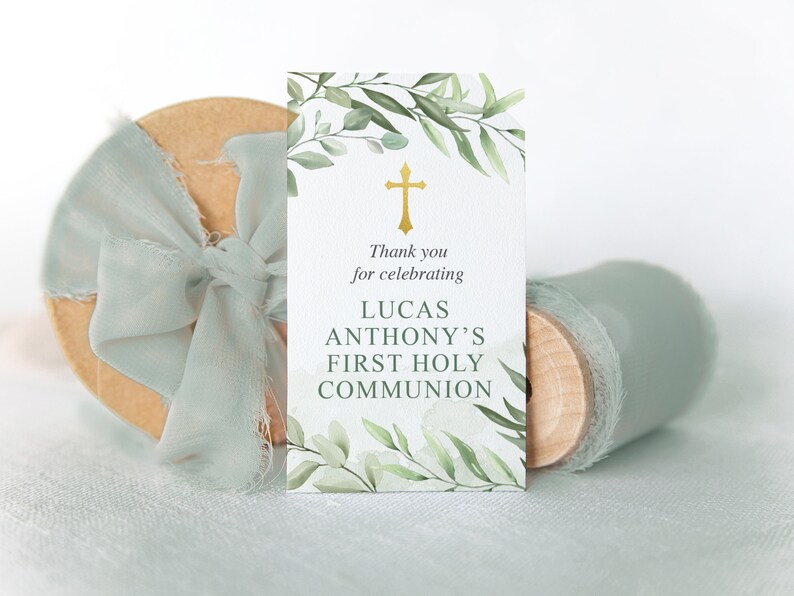 Puede incluir: Una tarjeta blanca con ramas verdes y una cruz dorada. El texto dice "Gracias por celebrar la Primera Comuni&oacute;n de Lucas Anthony".