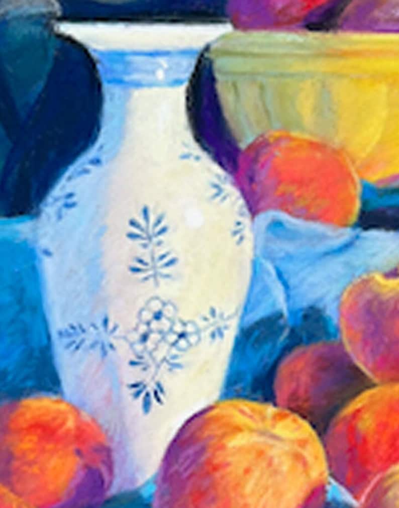May include: A white porcelain vase with blue floral designs sits on a blue cloth with a bowl of peaches and other fruit in the background.